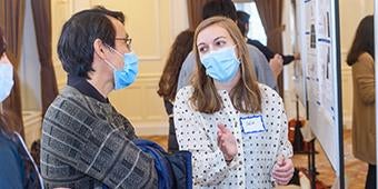 student presenting poster during biomedical symposium