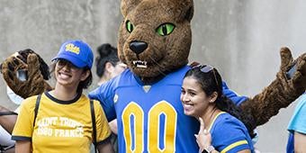 Pitt grad students posing with Roc the Panther during grad orientation picnic