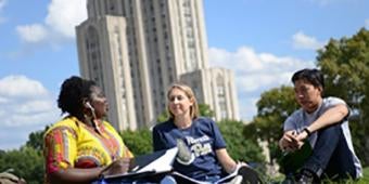 students sitting and talking on lawn